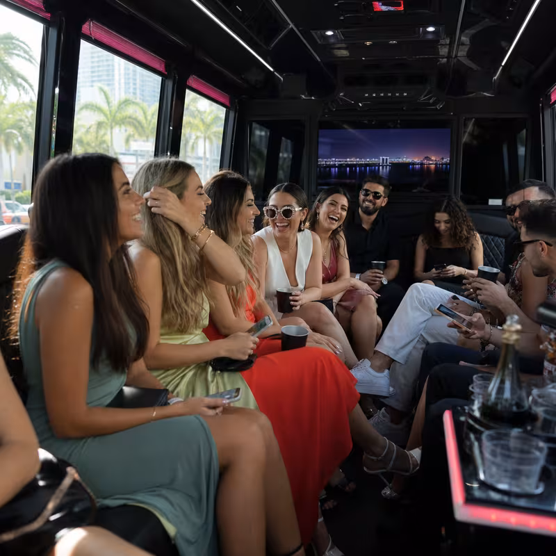 Party bus interior with wraparound leather seating and LED lighting in Miami