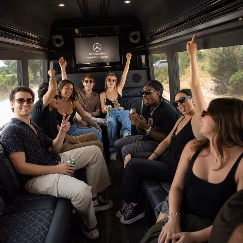 Group boarding a white charter bus for Concert Transportation transportation in Miami