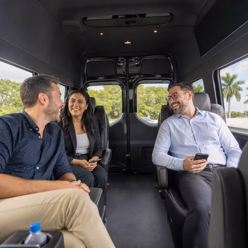 Group boarding a white charter bus for Corporate Transportation transportation in Miami