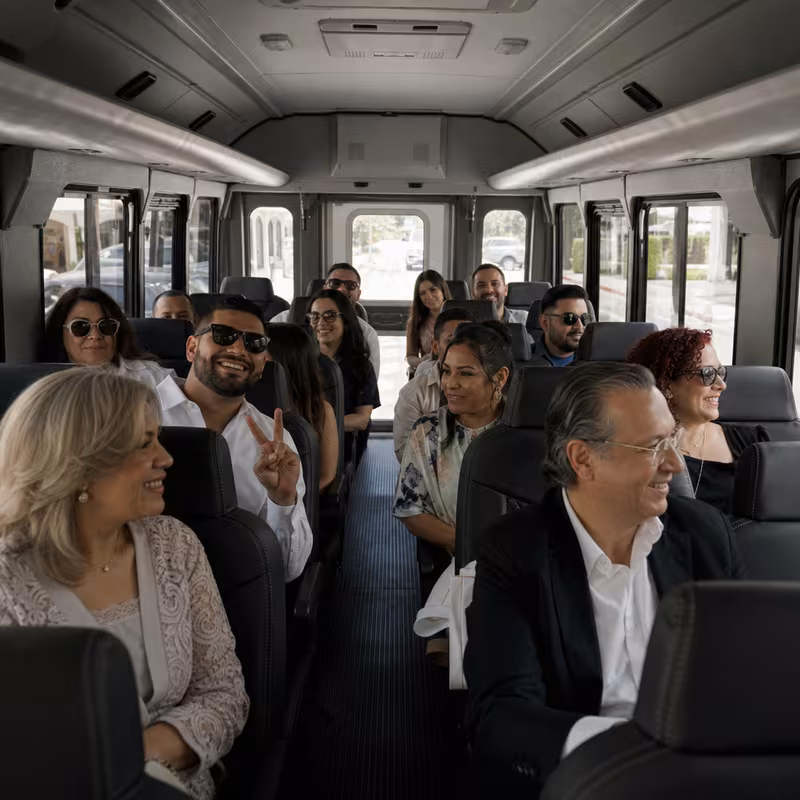 Group boarding a white charter bus for Private Event Transportation transportation in Miami