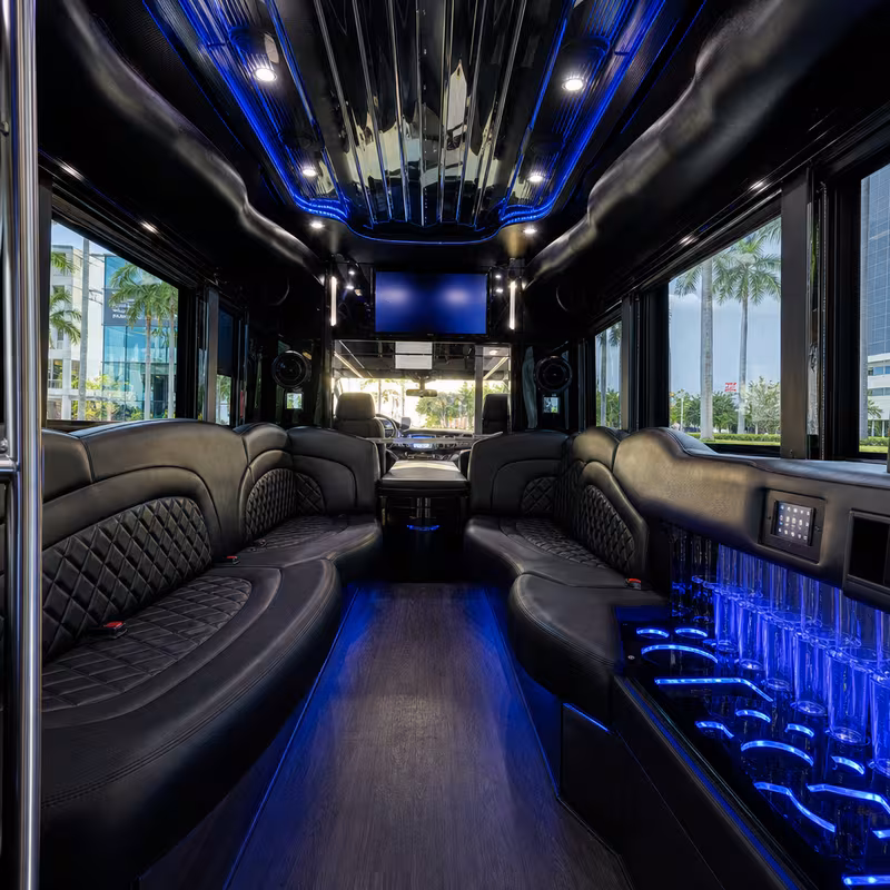 Party bus interior with wraparound leather seating and LED lighting in Miami
