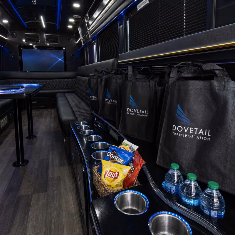 Party bus interior with wraparound leather seating and LED lighting in Miami